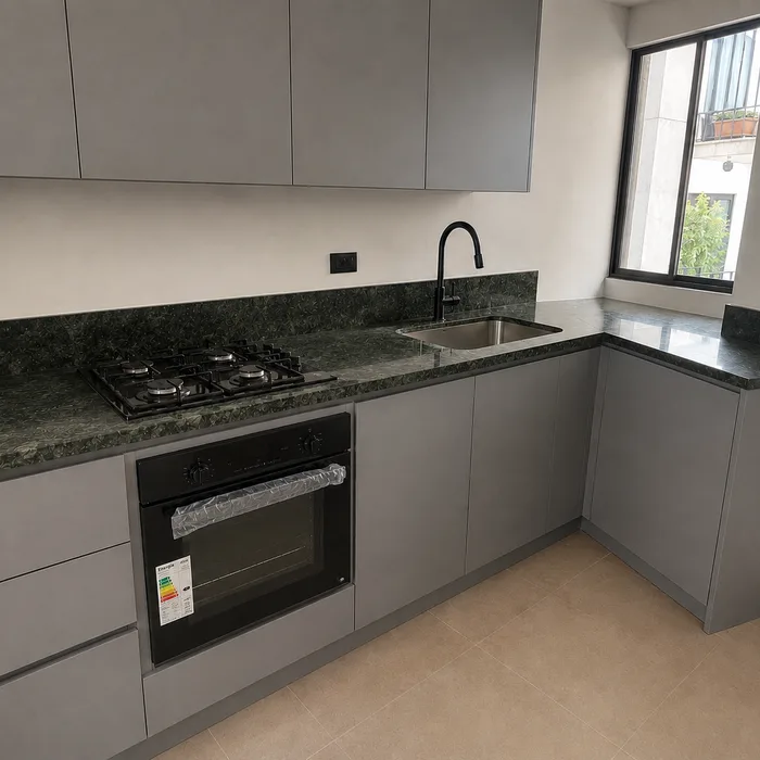 Cocina integral gris con encimera verde oscuro y electrodomésticos negros en Bucaramanga