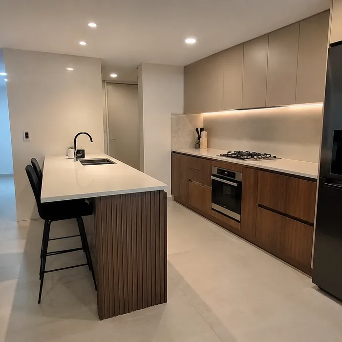 Cocina integral moderna en Bucaramanga con isla de madera, bancas negras y acabados blancos