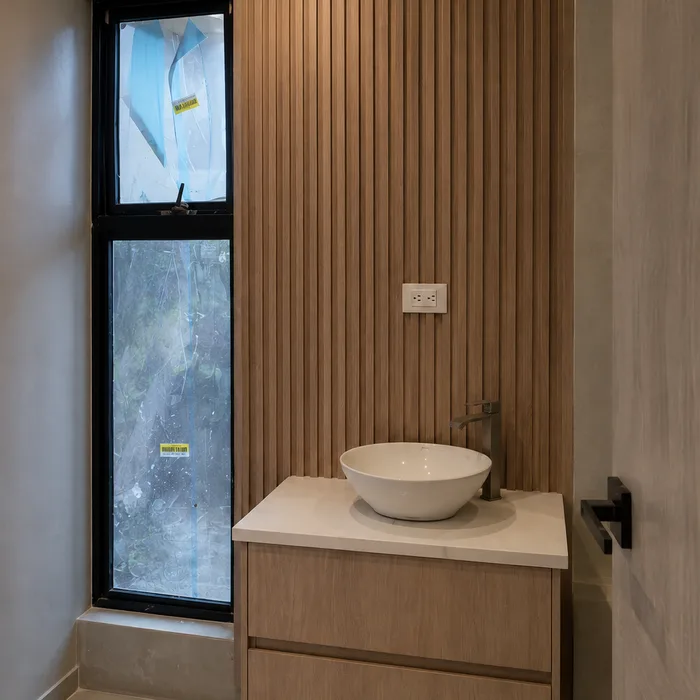 Lavamanos de cerámica blanca con mueble de madera en Bucaramanga con espejo decorativo