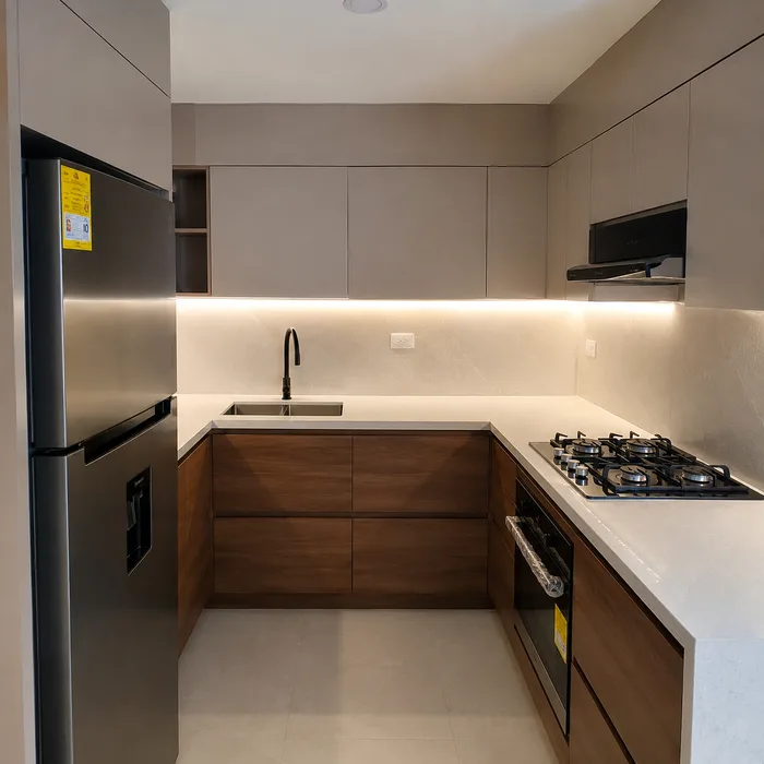 Cocina integral moderna en Bucaramanga con gabinetes café, encimera blanca y iluminación led empotrada