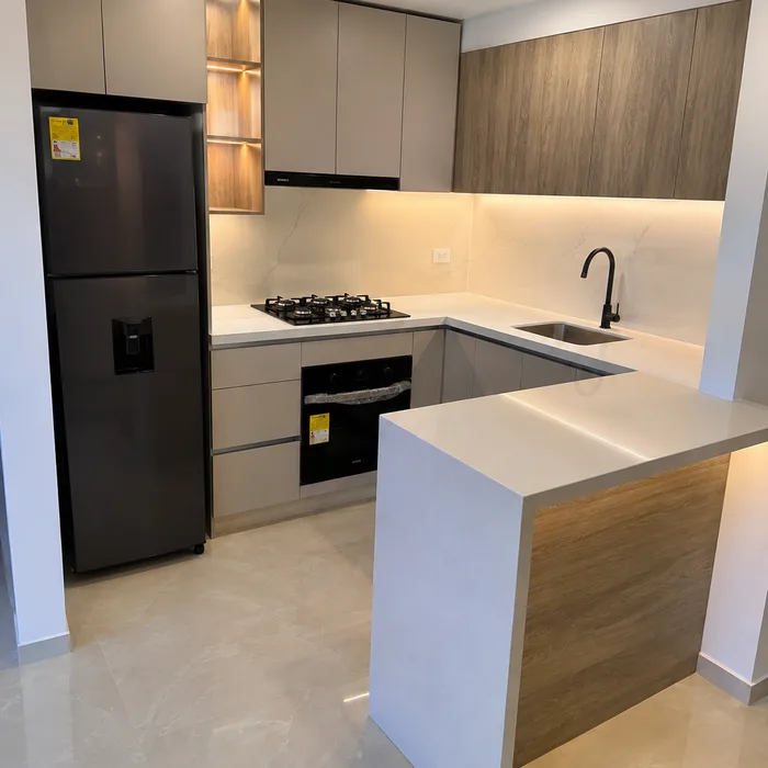 Cocina integral moderna en Bucaramanga con isla de madera, muebles blancos y electrodomésticos negros