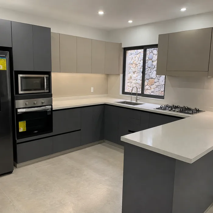 Cocina integral moderna en Bucaramanga con gabinetes grises y blancos, isla central y electrodomésticos negros