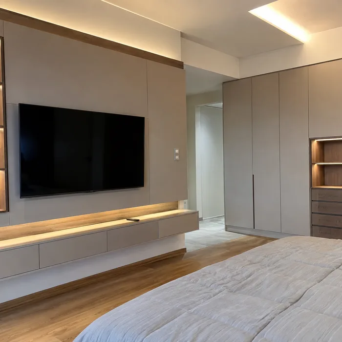 Recámara moderna en Bucaramanga con closet gris, TV empotrada y piso de madera
