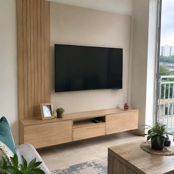 Mueble TV en madera clara con panelado vertical, diseñado en Bucaramanga