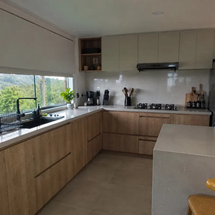 Cocina integral moderna en Bucaramanga con gabinetes en madera clara y encimera blanca