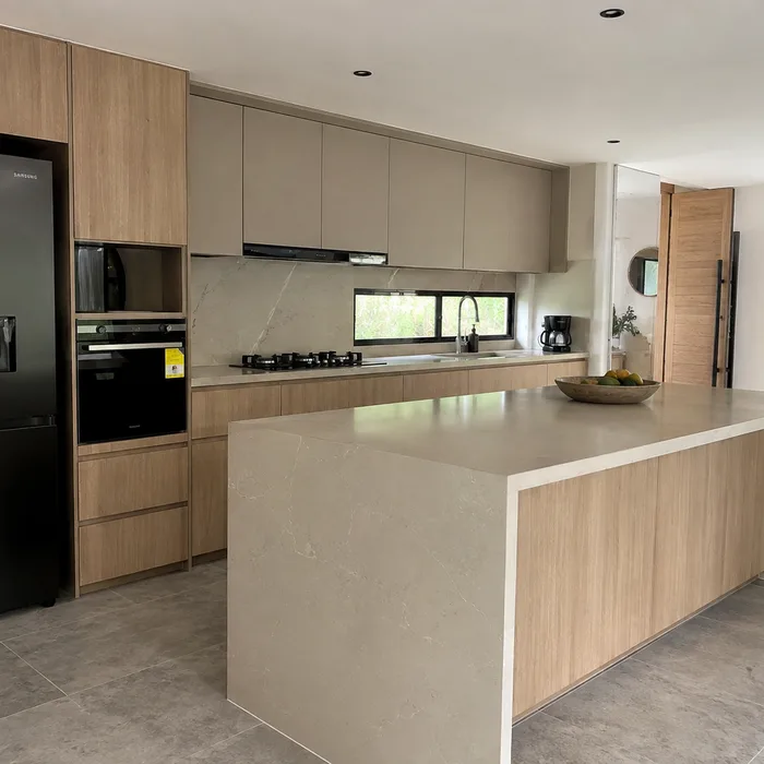 Cocina integral moderna en madera natural con isla y encimera gris en Bucaramanga