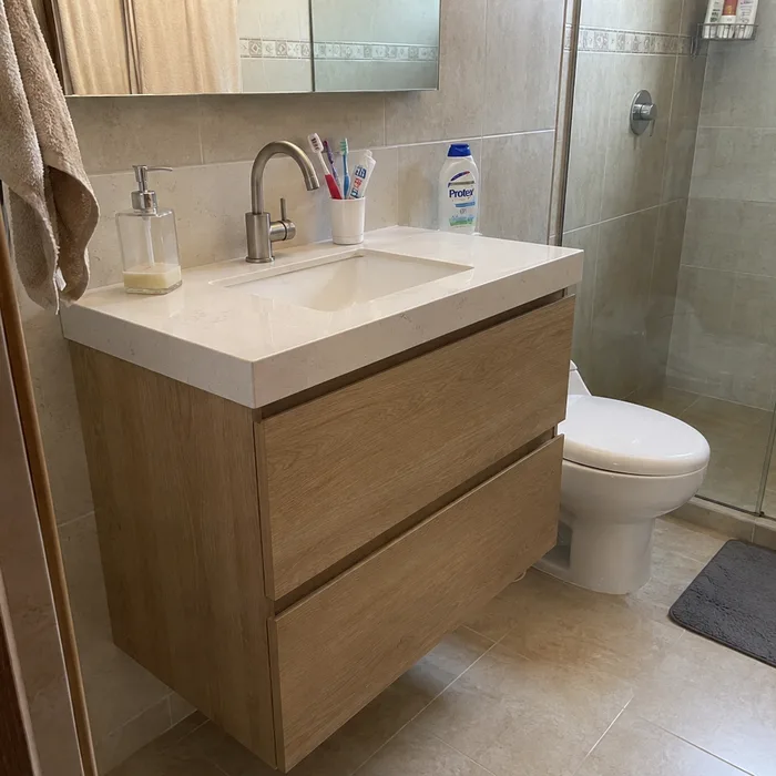 Mueble de baño en madera con lavamanos blanco instalado en Bucaramanga