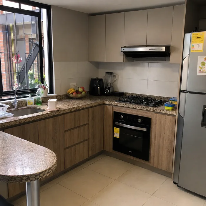 Cocina integral moderna en Bucaramanga con muebles en tonos madera y beige, encimera de granito